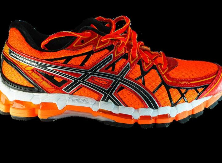 Chaussure de course orange et noire avec semelle blanche et noire