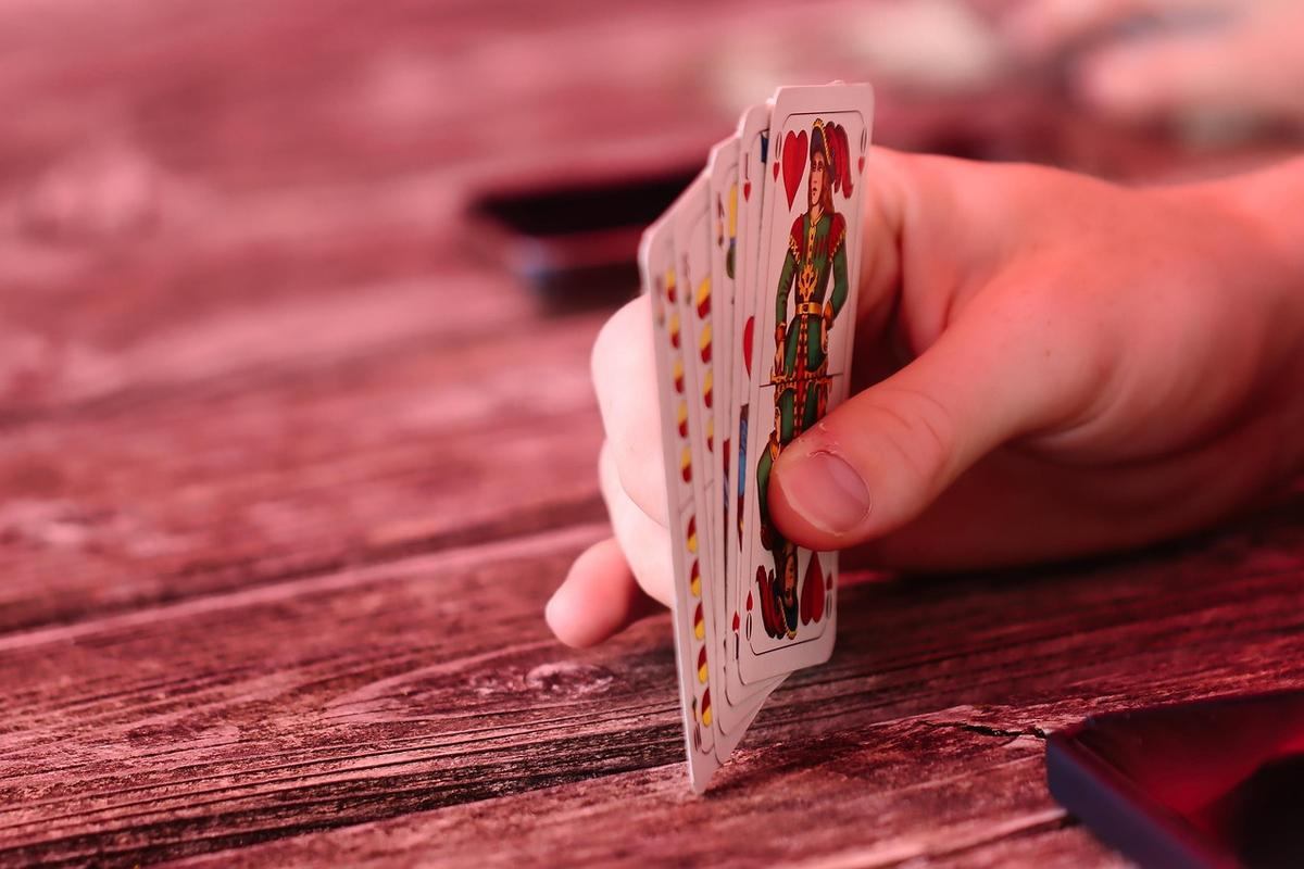 Des cartes à jouer et des dés posés sur une table en bois