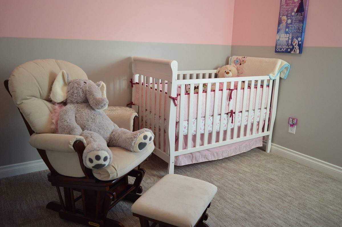 Chambre d'enfant avec cradle, fauteuil, jouets et couleurs pastel