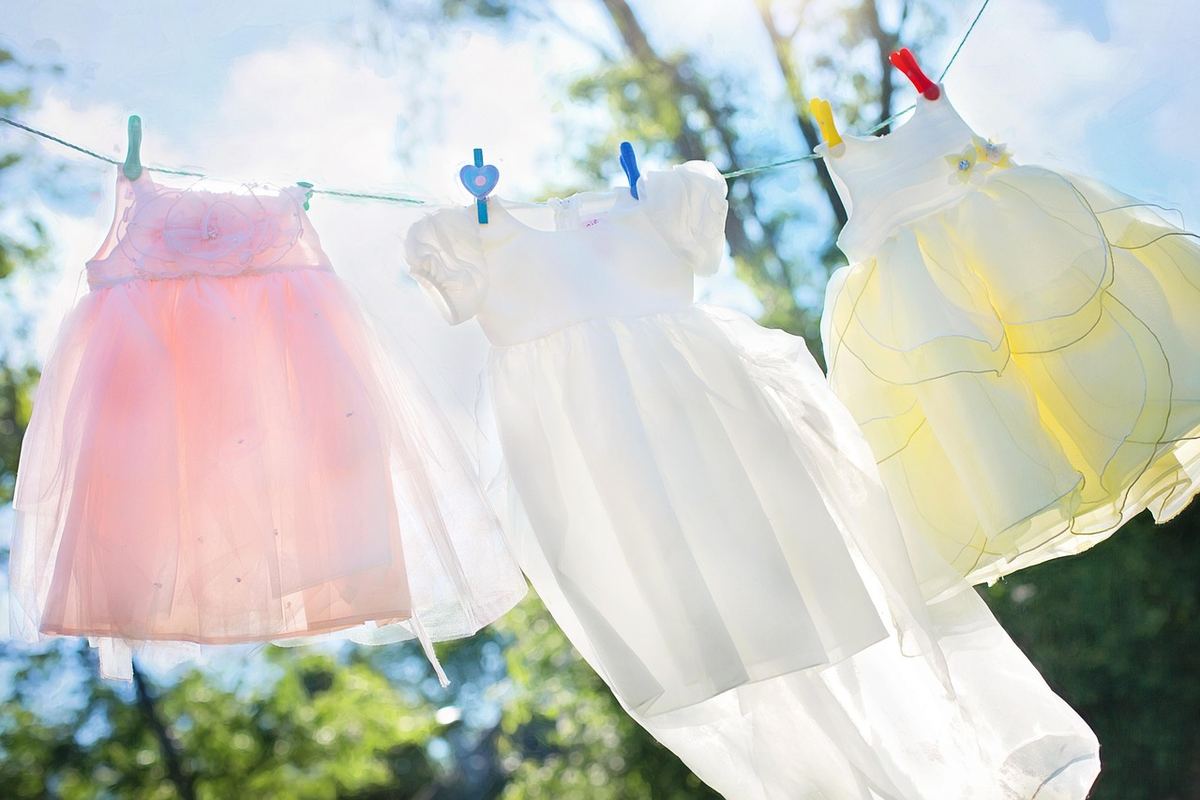 Trois petites robes suspendues en plein air, accrochées avec des pinces