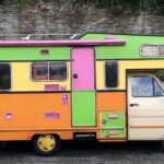 Camion‑caravane vintage aux couleurs vives stationné sur route