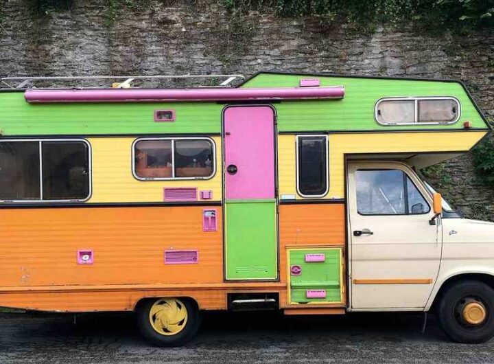 Camion‑caravane vintage aux couleurs vives stationné sur route