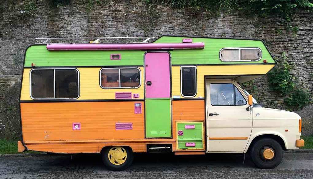 Camion‑caravane vintage aux couleurs vives stationné sur route
