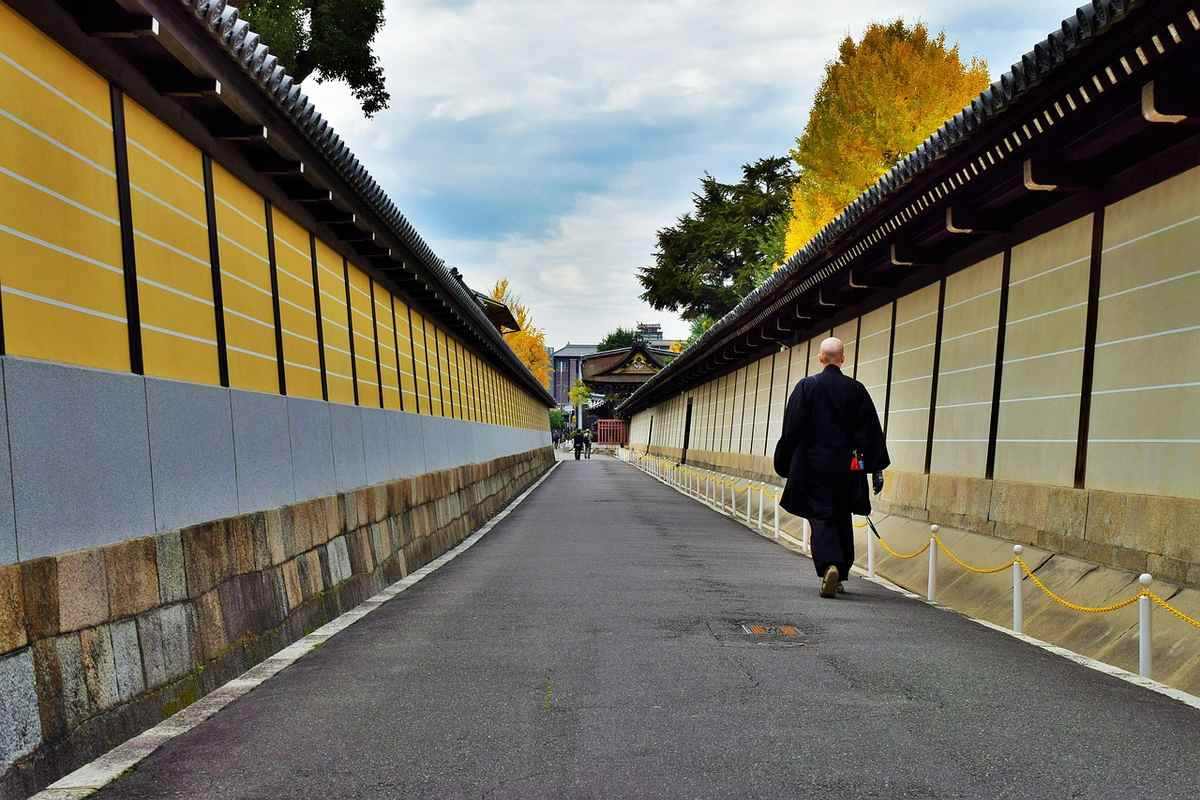 Un marcheur solitaire progresse sur un sentier entre hautes murailles jaunes et claires