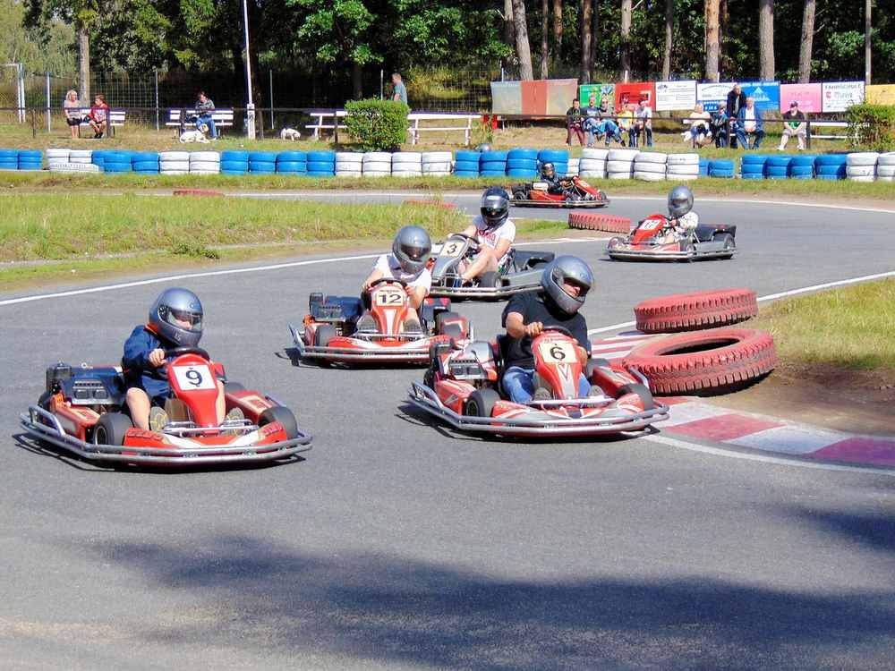 Plusieurs pilotes en karting tournent sur une piste asphaltée